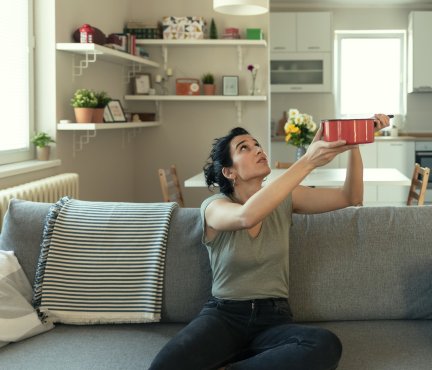 Vrouw houdt een pan vast om water op te vangen.