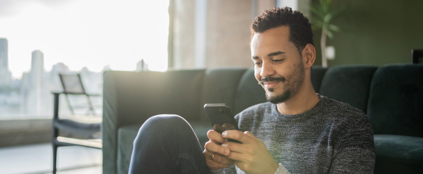 Homme qui fait une simulation de prêt sur son smartphone